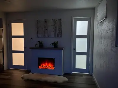 a living room with a fireplace and two doors at Apartment in Ft Collins in Fort Collins