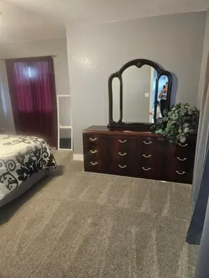 a bedroom with a bed and a dresser with a mirror at 3BR Lakewood • Free Parking + BBQ • Near Red Rocks in Lakewood