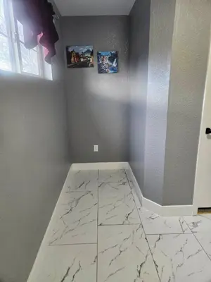 a room with a marble floor with two pictures on the wall at 3BR Lakewood • Free Parking + BBQ • Near Red Rocks in Lakewood