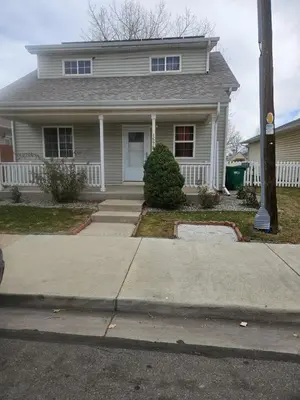 a white house with a porch and a driveway at 3BR Lakewood • Free Parking + BBQ • Near Red Rocks in Lakewood