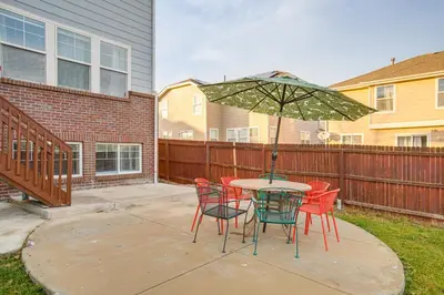 a table with chairs and an umbrella on a patio at Spacious Family Home at Buckley SFB with Patio! in Aurora