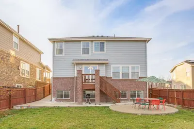 a house with a fence and a table in the yard at Spacious Family Home at Buckley SFB with Patio! in Aurora
