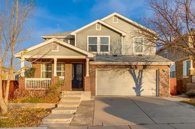a brick house with a garage at Spacious Family Home at Buckley SFB with Patio! in Aurora
