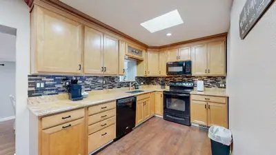 a large kitchen with wooden cabinets and black appliances at Family Home in Arvada with king beds and bunkbed in Arvada