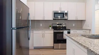 a kitchen with white cabinets and a stainless steel refrigerator at Landing Incredible 2BD Clubhouse Gym in Longmont