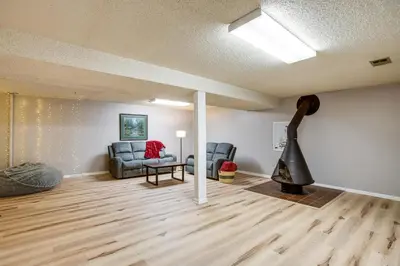 a living room with two chairs and a guitar at Gather Family! Home with Fenced Yard in Wheat Ridge in Wheat Ridge