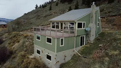 a green house on top of a hill at 10-Person HotTub, ViewHouse, Steps to Trail, Close to Ski Resorts, FirePit in Silverthorne