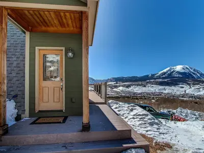 a front door of a house with a snow covered mountain at 10-Person HotTub, ViewHouse, Steps to Trail, Close to Ski Resorts, FirePit in Silverthorne