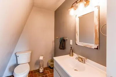 a bathroom with a toilet and a sink and a mirror at 10-Person HotTub, ViewHouse, Steps to Trail, Close to Ski Resorts, FirePit in Silverthorne