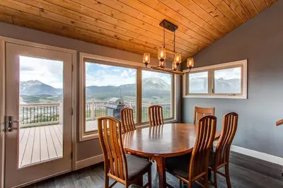 a dining room with a table and chairs and a large window at 10-Person HotTub, ViewHouse, Steps to Trail, Close to Ski Resorts, FirePit in Silverthorne
