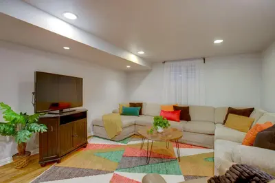 a living room with a couch and a tv at 9 Mi to Red Rocks Modern Getaway with Private Yard in Lakewood