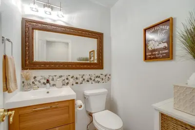 a bathroom with a toilet and a sink and a mirror at 9 Mi to Red Rocks Modern Getaway with Private Yard in Lakewood