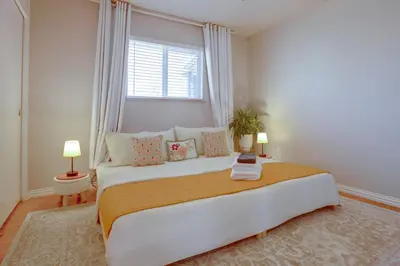 a bedroom with a large bed with a window at 9 Mi to Red Rocks Modern Getaway with Private Yard in Lakewood