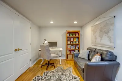 a living room with a leather couch and a desk at 9 Mi to Red Rocks Modern Getaway with Private Yard in Lakewood