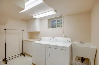 a white kitchen with a sink and a washer at 9 Mi to Red Rocks Modern Getaway with Private Yard in Lakewood