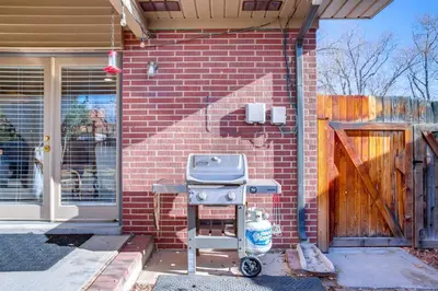 a barbecue grill in front of a brick house at 9 Mi to Red Rocks Modern Getaway with Private Yard in Lakewood