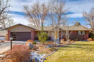 a brick house with a garage at 9 Mi to Red Rocks Modern Getaway with Private Yard in Lakewood