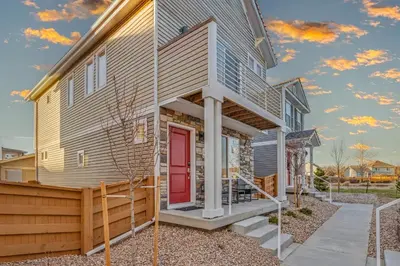 a house with a red door and a porch at Modern 2BR 2BA Townhome 15 Min to DEN in Commerce City