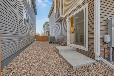 a walkway leading to the side of a building at Modern 2BR 2BA Townhome 15 Min to DEN in Commerce City