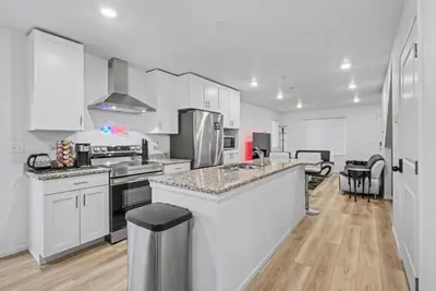 a kitchen with white cabinets and stainless steel appliances at Modern 2BR 2BA Townhome 15 Min to DEN in Commerce City