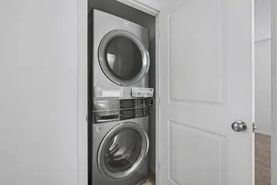 a washer and dryer in a room with a door at Modern 2BR 2BA Townhome 15 Min to DEN in Commerce City