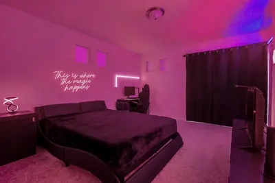 a bedroom with a bed in a pink room at Modern 2BR 2BA Townhome 15 Min to DEN in Commerce City