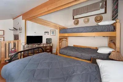 a bedroom with two bunk beds and a television at Wild Irishman 2 bed 1 and half bath WIGK in Keystone