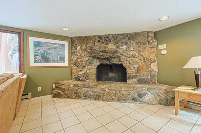 a stone fireplace in a living room with green walls at Wild Irishman 2 bed 1 and half bath WIGK in Keystone