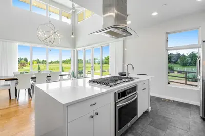 a kitchen with white cabinets and a table with chairs at Perfectly Between Boulder- Estes in Longmont