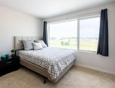 a bedroom with a bed and a large window at Perfectly Between Boulder- Estes in Longmont