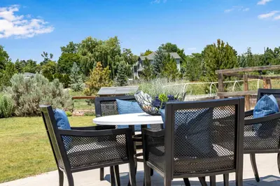 a patio with three chairs and a table with a bowl on it at Perfectly Between Boulder- Estes in Longmont