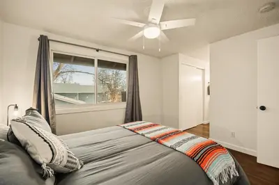 a bedroom with a bed with a ceiling fan and a window at The Loveland Haus in Loveland