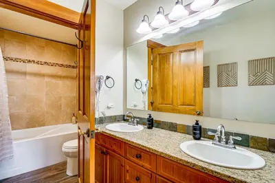 a bathroom with two sinks and a toilet and a mirror at Walk to Gondola! Keystone Gem in River Run Village in Keystone