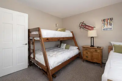 a bedroom with two bunk beds and a night stand at Comfortable Mountain Getaway near Winter Park in Fraser