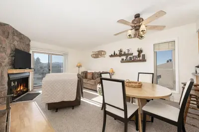 a living room with a table and a fireplace at Comfortable Mountain Getaway near Winter Park in Fraser
