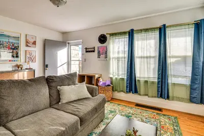 a living room with a couch and blue curtains at 7 Mi to Dtwn Denver Pet-Friendly Home with Yard in Aurora