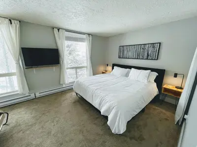a bedroom with a large white bed and a tv at Spacious Dillon Basecamp, close to resorts! in Dillon