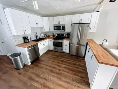 a kitchen with white cabinets and a stainless steel refrigerator at Spacious Dillon Basecamp, close to resorts! in Dillon