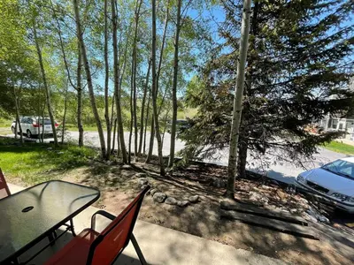 a patio with a table and chairs in the woods at Spacious Dillon Basecamp, close to resorts! in Dillon