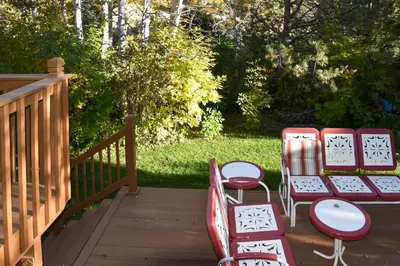 a couple of chairs and tables on a deck at 6 Mi to Dtwn Fort Collins Cozy Apt with Shared Yard in Fort Collins