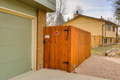 a wooden gate in front of a house with a garage at 6 Mi to Dtwn Fort Collins Cozy Apt with Shared Yard in Fort Collins