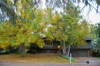 a house with a dog sitting in front of it at 6 Mi to Dtwn Fort Collins Cozy Apt with Shared Yard in Fort Collins