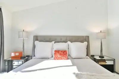 a bedroom with a white bed with two lamps at You Are My Sunshine - Downtown Frisco Home in Frisco