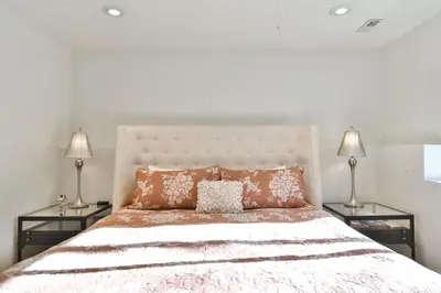 a bedroom with a large bed with two lamps at You Are My Sunshine - Downtown Frisco Home in Frisco
