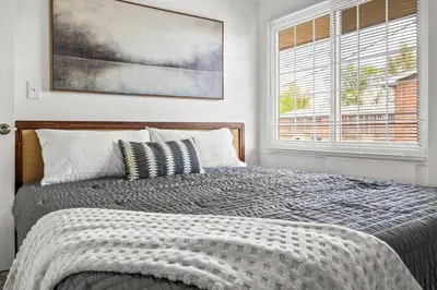 a bedroom with a bed and a large window at Prime Location - Walking Distance to Old Town Arvada - 2 bedrooms 3 beds 1 bath in Arvada