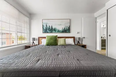 a bedroom with a large bed with green pillows at Prime Location - Walking Distance to Old Town Arvada - 2 bedrooms 3 beds 1 bath in Arvada