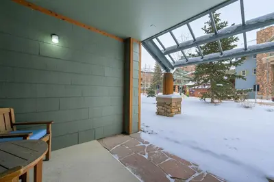 a patio with snow on the ground and a window at Premium Unit 1100 - One Bedroom - Zephyr Mountain Lodge condo in Winter Park