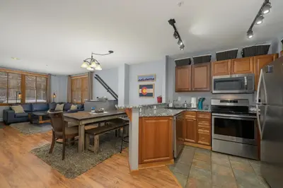 a kitchen and living room with a table and a couch at Premium Unit 1100 - One Bedroom - Zephyr Mountain Lodge condo in Winter Park