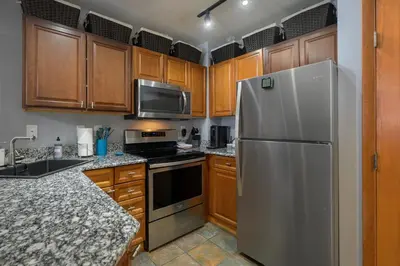 a kitchen with wooden cabinets and a stainless steel refrigerator at Premium Unit 1100 - One Bedroom - Zephyr Mountain Lodge condo in Winter Park