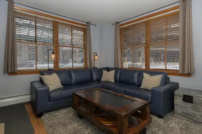 a living room with a blue couch and a coffee table at Premium Unit 1100 - One Bedroom - Zephyr Mountain Lodge condo in Winter Park